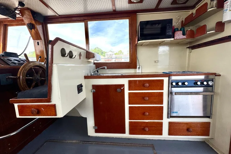 Slide: The Image of Interior of a 1976 Downeast Flybridge Cruiser with wooden cabinetry and steering wheel. - 17