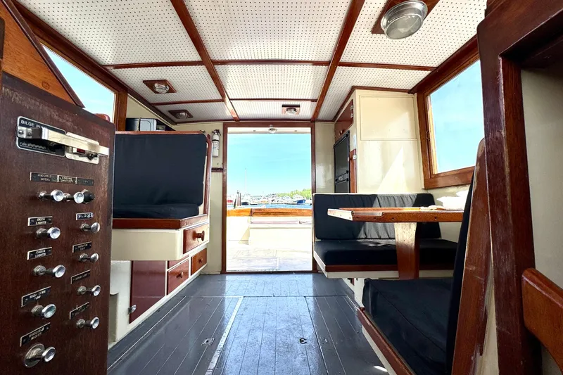 Slide: The Image of Interior of a 1976 Downeast Flybridge Cruiser with wood paneling and seating area. - 20