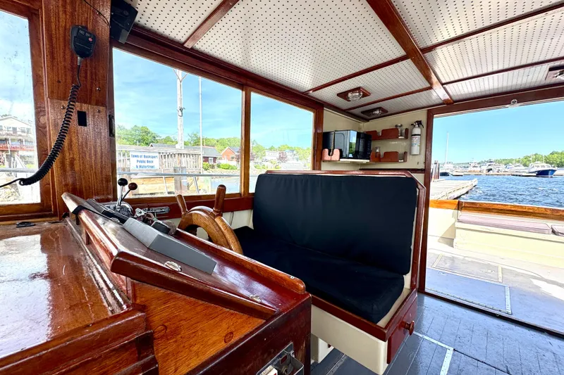 Slide: The Image of Interior of a 1976 Downeast Flybridge Cruiser with wooden helm and waterfront view. - 21