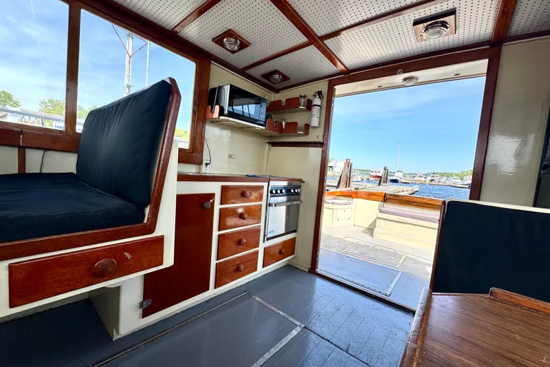 Slide: The Image of Interior of a 1976 Downeast Flybridge Cruiser with wooden cabinetry and waterfront view. - 22