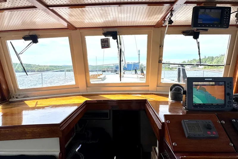 Slide: The Image of Interior view of 1976 Downeast Flybridge Cruiser with navigation equipment and scenic waterway. - 26