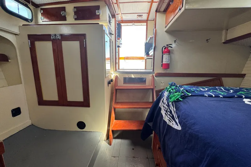 Slide: The Image of Interior of a 1976 Downeast Flybridge Cruiser with wooden cabinetry and stairs. - 29