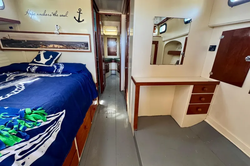 Slide: The Image of 1976 Downeast Flybridge Cruiser cabin with nautical decor, bed, and vanity area. - 30