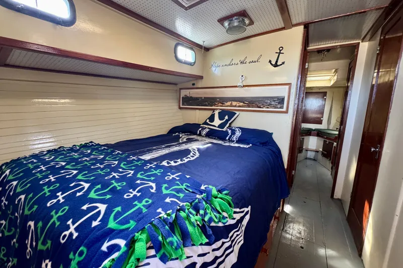 Slide: The Image of Cozy cabin interior of 1976 Downeast Flybridge Cruiser with nautical-themed bedding and decor. - 31