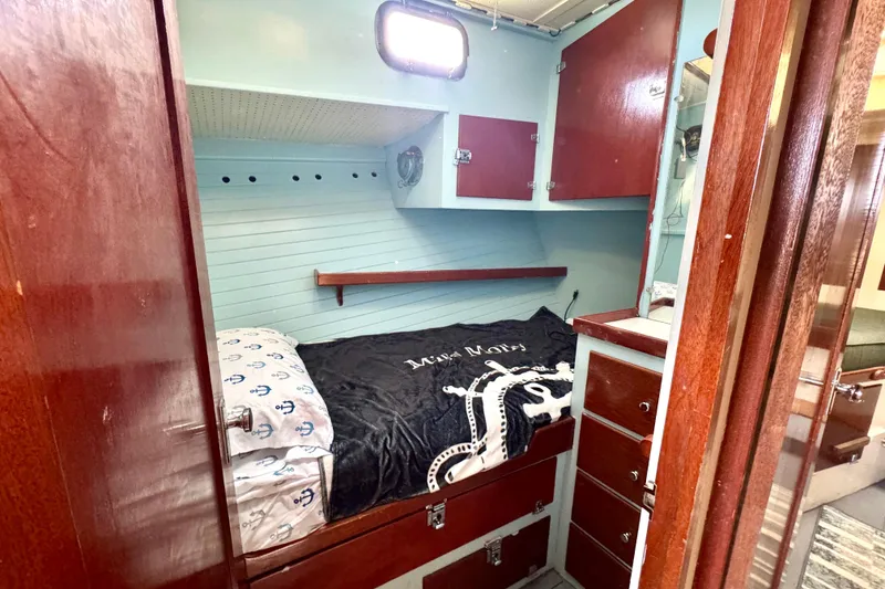 Slide: The Image of 1976 Downeast Flybridge Cruiser cabin with wooden cabinetry and cozy sleeping area. - 38