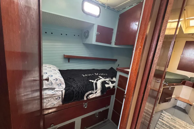 Slide: The Image of 1976 Downeast Flybridge Cruiser cabin with wooden interior and cozy bedding. - 40