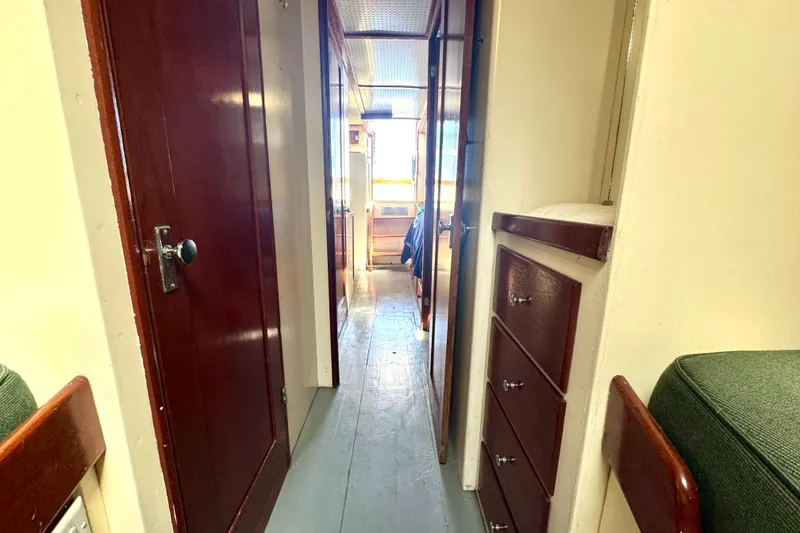 Slide: The Image of Interior hallway of a 1976 Downeast Flybridge Cruiser with wooden doors and drawers. - 41