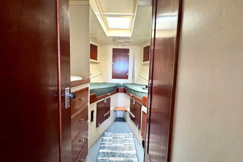 Slide: The Image of 1976 Downeast Flybridge Cruiser cabin interior with wooden cabinetry and cozy sleeping area. - 42