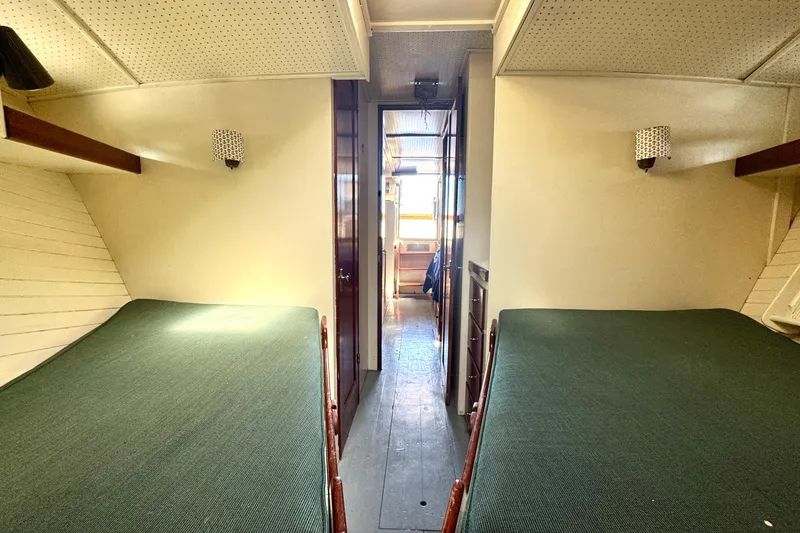 Slide: The Image of 1976 Downeast Flybridge Cruiser cabin interior with twin beds and hallway view. - 46