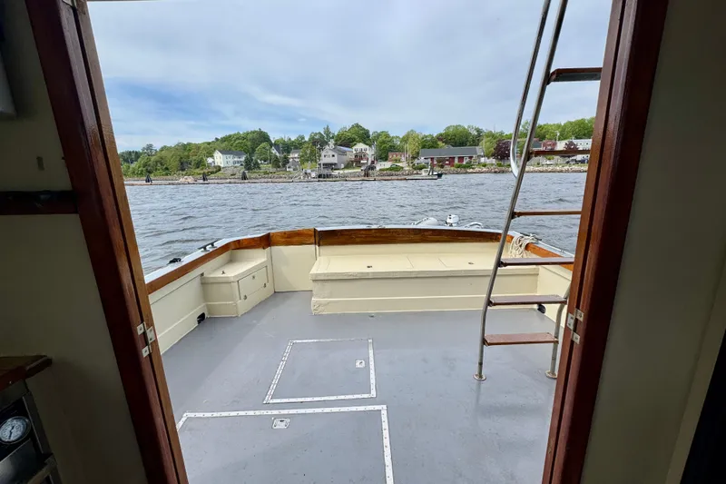 Slide: The Image of 1976 Downeast Flybridge Cruiser deck view with waterfront scenery in the background. - 51
