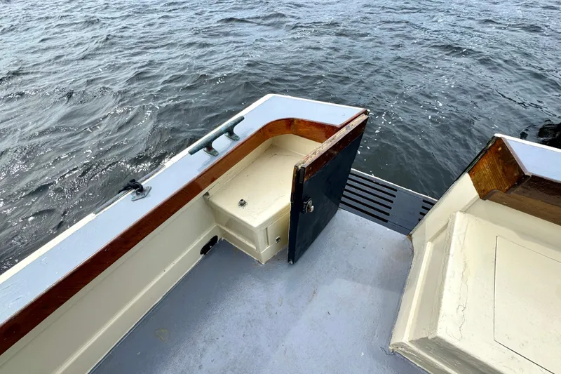 Slide: The Image of 1976 Downeast Flybridge Cruiser deck with open hatch, overlooking water. - 53