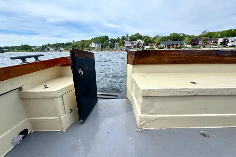 Slide: The Image of 1976 Downeast Flybridge Cruiser with open deck view, overlooking serene waterfront homes. - 54