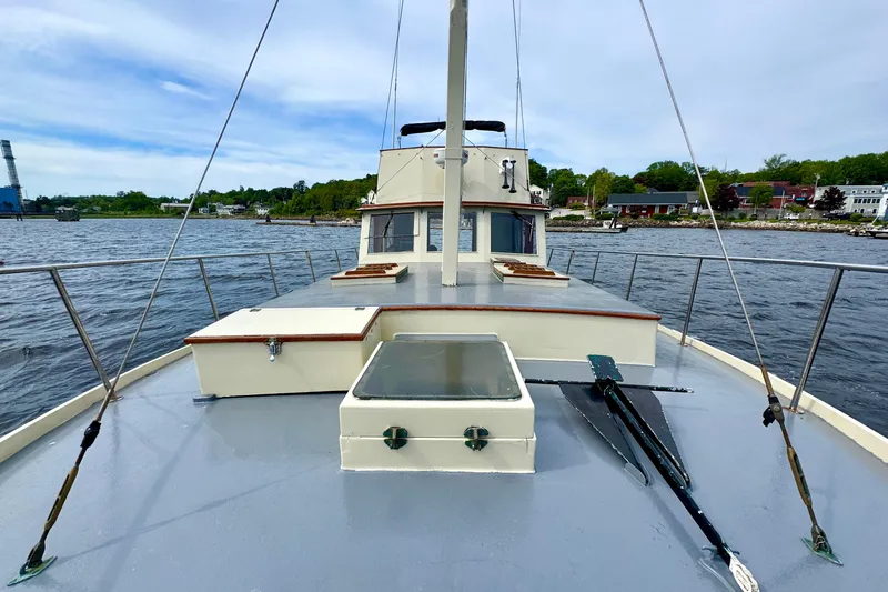 Slide: The Image of 1976 Downeast Flybridge Cruiser on calm waters, showcasing classic design and spacious deck. - 63