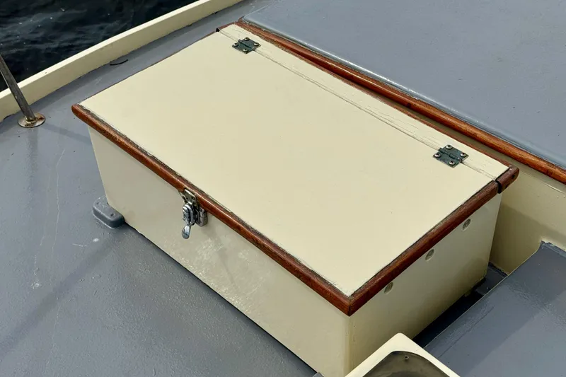 Slide: The Image of 1976 Downeast Flybridge Cruiser deck with a secured storage box. - 64
