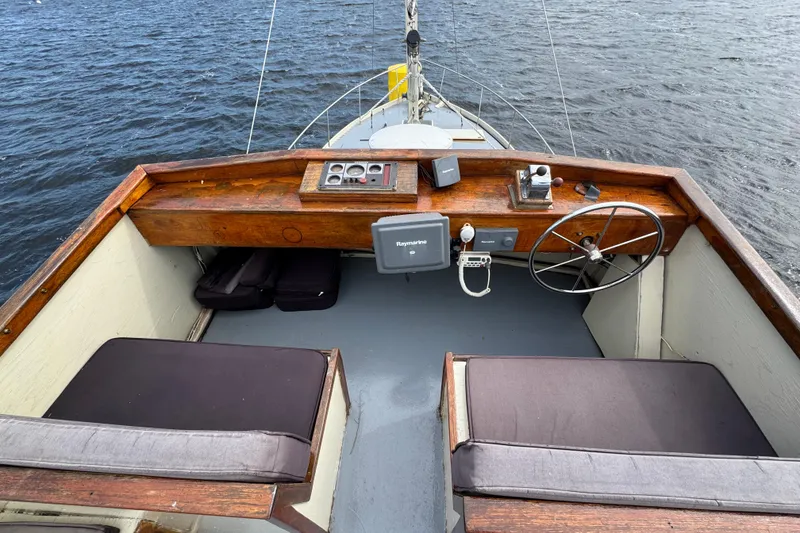 Slide: The Image of 1976 Downeast Flybridge Cruiser helm with wooden dashboard and nautical equipment. - 71