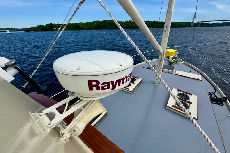 Slide: The Image of 1976 Downeast Flybridge Cruiser on water, featuring Raymarine radar, scenic backdrop. - 74