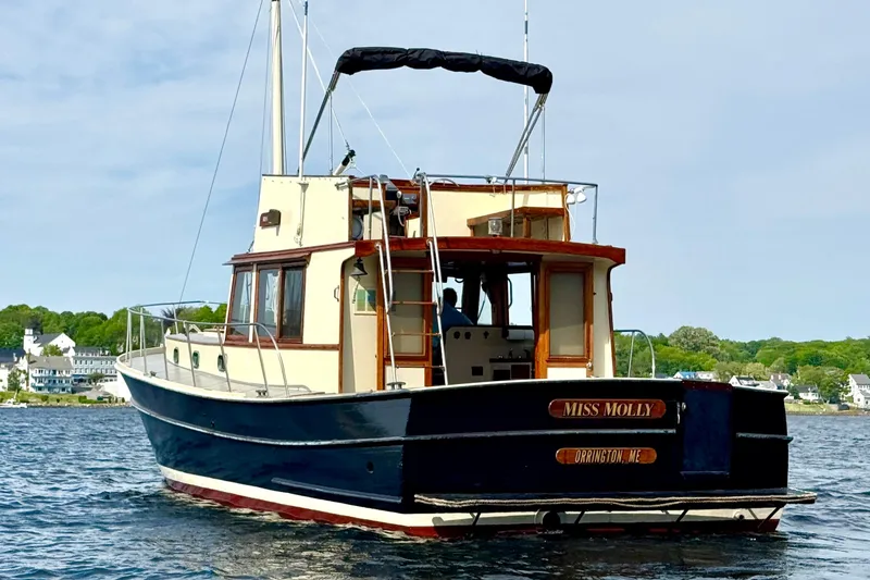 Slide: The Image of 1976 Downeast Flybridge Cruiser on water, featuring classic design and elegant wood accents. - 75