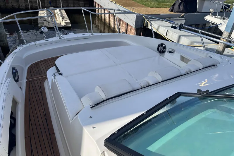 Slide: The Image of 2020 Sea Ray Sundancer 320 Coupe with white seating and wooden deck at a marina. - 16