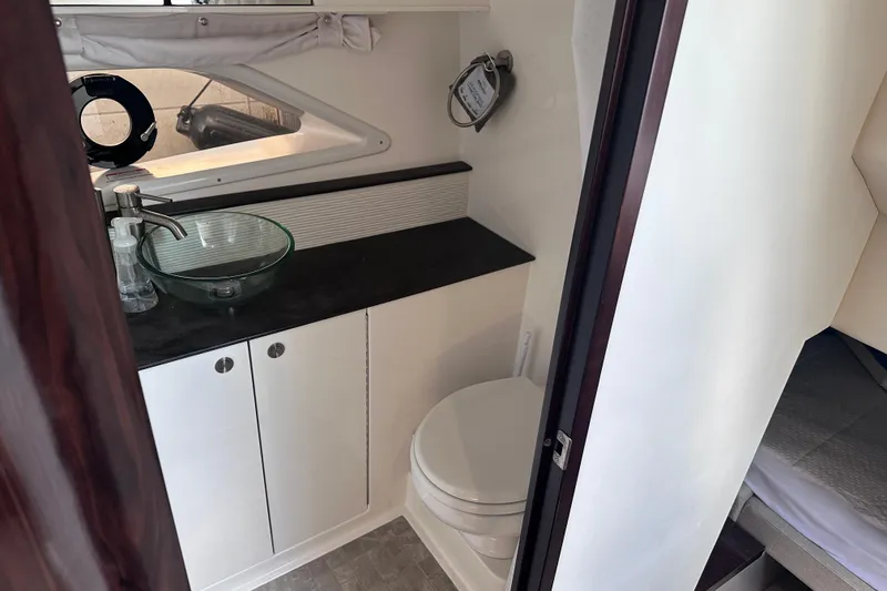 Slide: The Image of Interior of 2020 Sea Ray Sundancer 320 Coupe, featuring a compact bathroom with modern fixtures. - 28