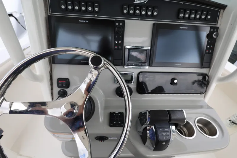 Slide: The Image of Control panel of a 2016 Boston Whaler 250 Outrage boat with steering wheel and navigation screens. - 11