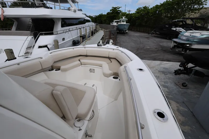 Slide: The Image of 2016 Boston Whaler 250 Outrage boat with spacious seating, docked near other vessels. - 15
