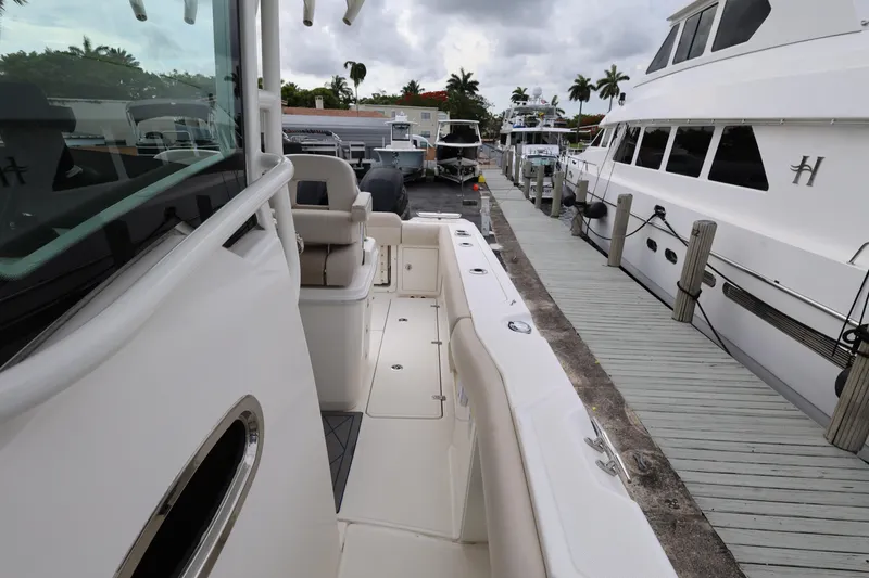 Slide: The Image of 2016 Boston Whaler 250 Outrage docked, showcasing sleek design and spacious deck. - 20