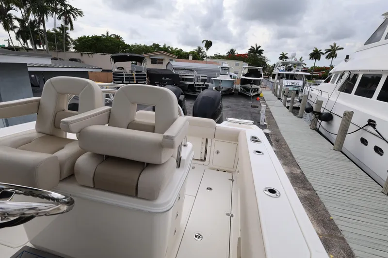 Slide: The Image of 2016 Boston Whaler 250 Outrage boat docked, featuring comfortable seating and sleek design. - 21