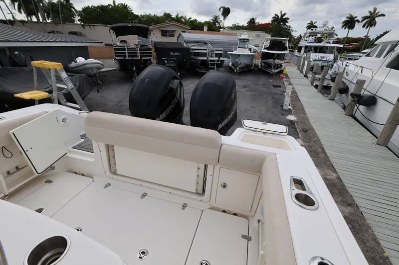 Slide: The Image of 2016 Boston Whaler 250 Outrage boat docked, featuring dual Mercury engines and spacious seating. - 22