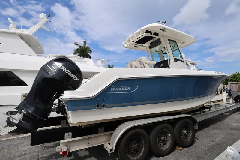 Slide: The Image of 2016 Boston Whaler 250 Outrage boat on trailer, featuring Mercury outboard engine. - 3
