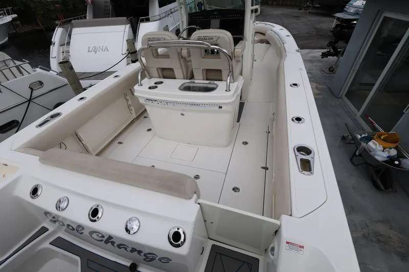 Slide: The Image of 2016 Boston Whaler 250 Outrage boat interior, featuring spacious seating and fishing rod holders. - 6