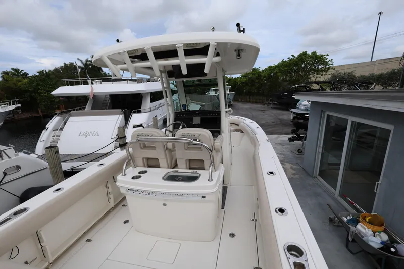 Slide: The Image of 2016 Boston Whaler 250 Outrage boat docked, showcasing spacious deck and seating area. - 7
