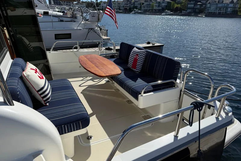 Slide: The Image of 2017 Sabre 38 Salon Express yacht with elegant seating and table on deck by the water. - 21