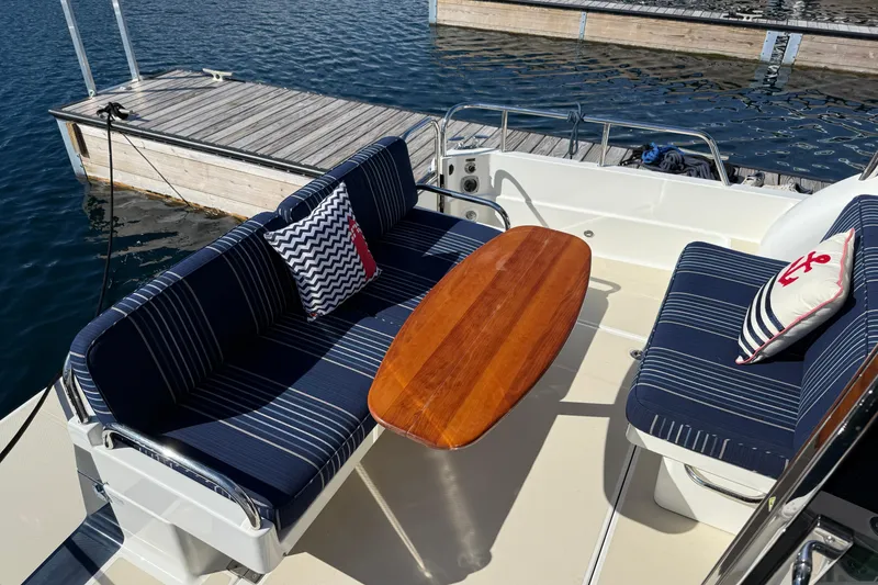 Slide: The Image of 2017 Sabre 38 Salon Express boat with striped seating and wooden table at dock. - 23
