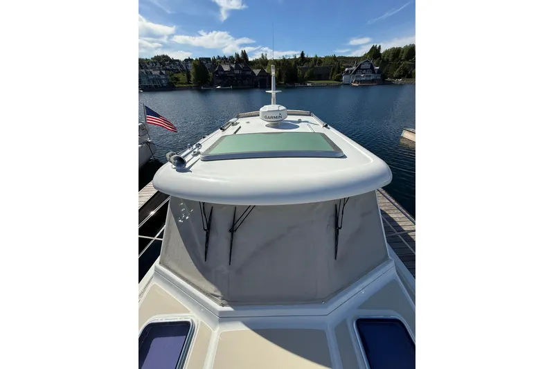 Slide: The Image of 2017 Sabre 38 Salon Express yacht docked on a serene lake with clear skies. - 30