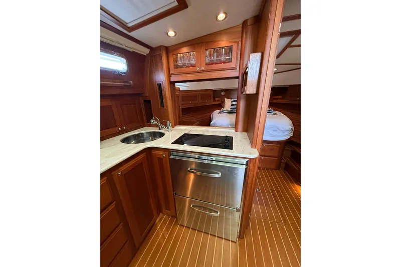 Slide: The Image of 2017 Sabre 38 Salon Express interior with wood cabinetry, compact kitchen, and cozy sleeping area. - 61