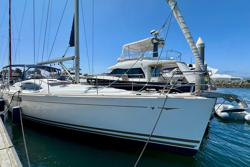 The Image of 2014 Jeanneau Sun Odyssey 50 DS sailboat docked at marina under clear blue sky. - 1