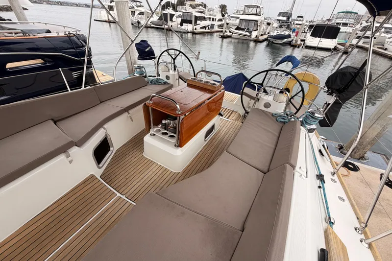 Slide: The Image of 2014 Jeanneau Sun Odyssey 50 DS sailboat cockpit with dual steering wheels in marina. - 24