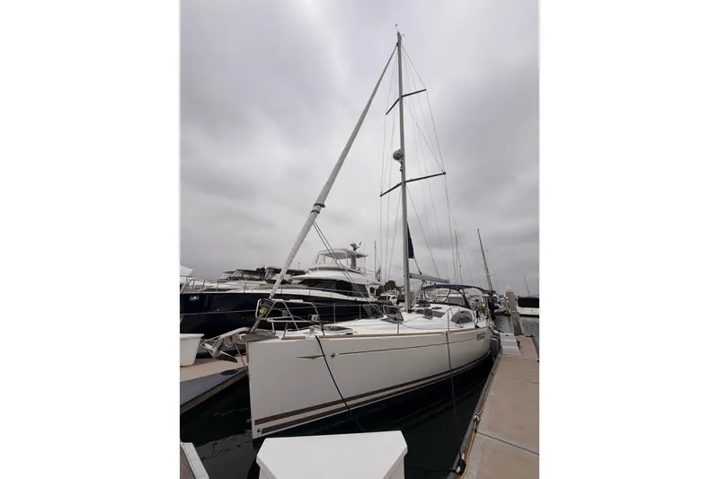 Slide: The Image of 2014 Jeanneau Sun Odyssey 50 DS sailboat docked at marina under cloudy sky. - 3