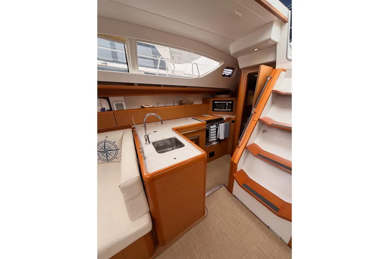 Slide: The Image of Interior of 2014 Jeanneau Sun Odyssey 50 DS yacht, featuring modern kitchen and wooden cabinetry. - 42