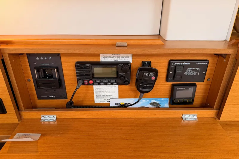 Slide: The Image of Control panel of a 2014 Jeanneau Sun Odyssey 50 DS sailboat, featuring communication and generator systems. - 52