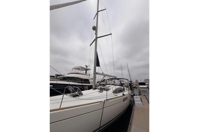 Slide: The Image of 2014 Jeanneau Sun Odyssey 50 DS sailboat docked at marina under cloudy sky. - 6