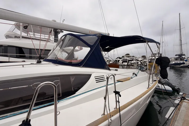 Slide: The Image of 2014 Jeanneau Sun Odyssey 50 DS sailboat docked in marina, featuring sleek design and blue canopy. - 8