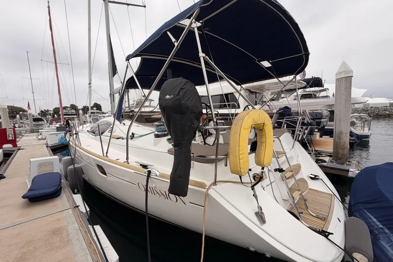 Slide: The Image of 2014 Jeanneau Sun Odyssey 50 DS sailboat docked at marina with blue canopy. - 9