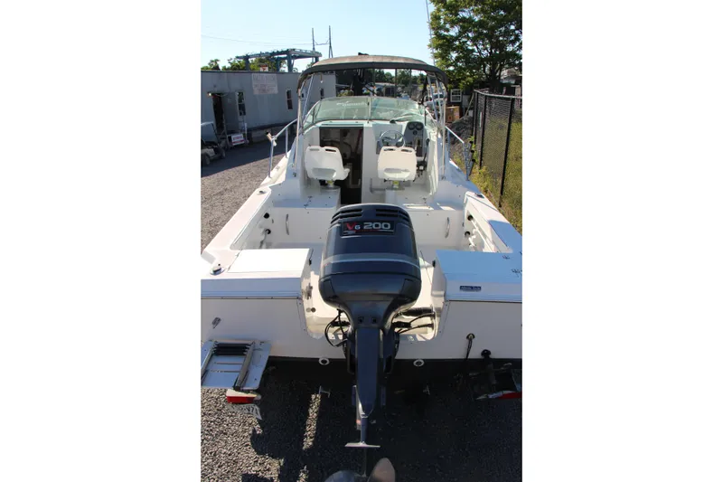 Slide: The Image of 2003 Aquasport 215 Explorer boat with V6 engine, rear view in outdoor setting. - 13