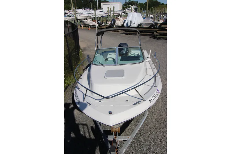 Slide: The Image of 2003 Aquasport 215 Explorer boat on trailer in marina setting. - 14