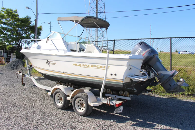 Slide: The Image of 2003 Aquasport 215 Explorer boat on trailer with Yamaha outboard motor. - 4