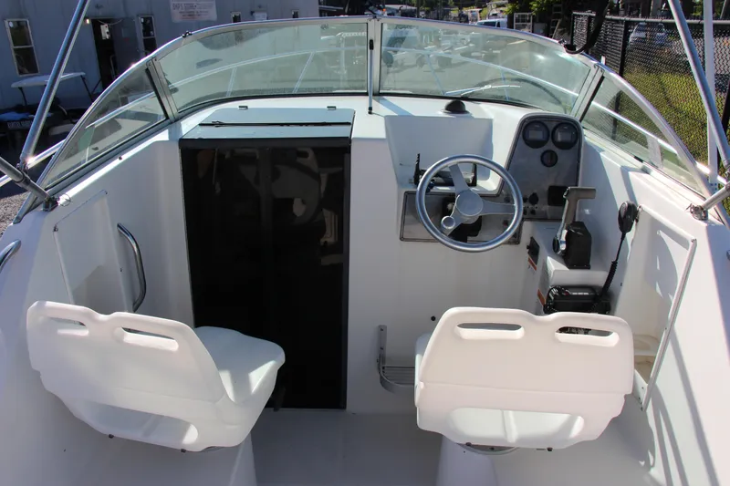 Slide: The Image of 2003 Aquasport 215 Explorer boat cockpit with steering wheel and dual seats. - 5