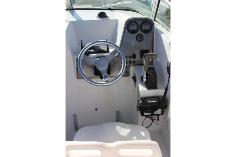 Slide: The Image of 2003 Aquasport 215 Explorer boat cockpit with steering wheel and control panel. - 8