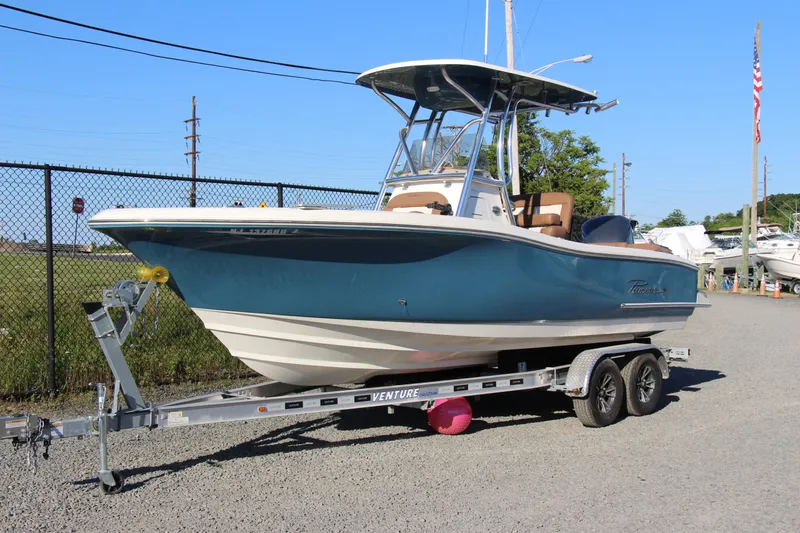 The Image of 2022 Pioneer 222 Islander boat on trailer, blue hull, parked outdoors. - 0
