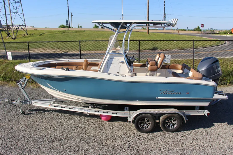 Slide: The Image of 2022 Pioneer 222 Islander boat on trailer, blue hull, parked outdoors. - 3